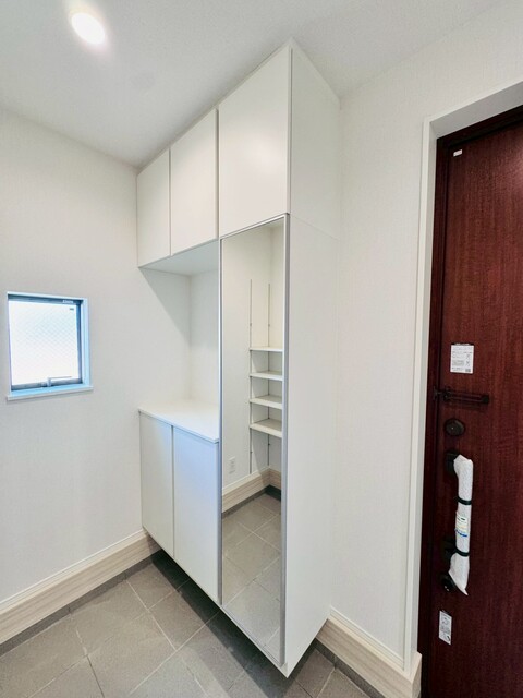 【2号棟】<br>天井までの高さがあるたっぷり玄関収納。大容量のコの字型タイプで鍵などの小物も置けるスペースがあります。のスライド画像