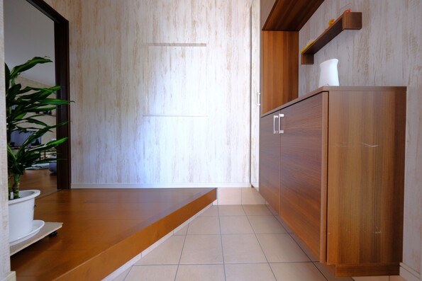 【玄関】幅広の框(かまち)写真左奥にコートクロークを備えた玄関ホール