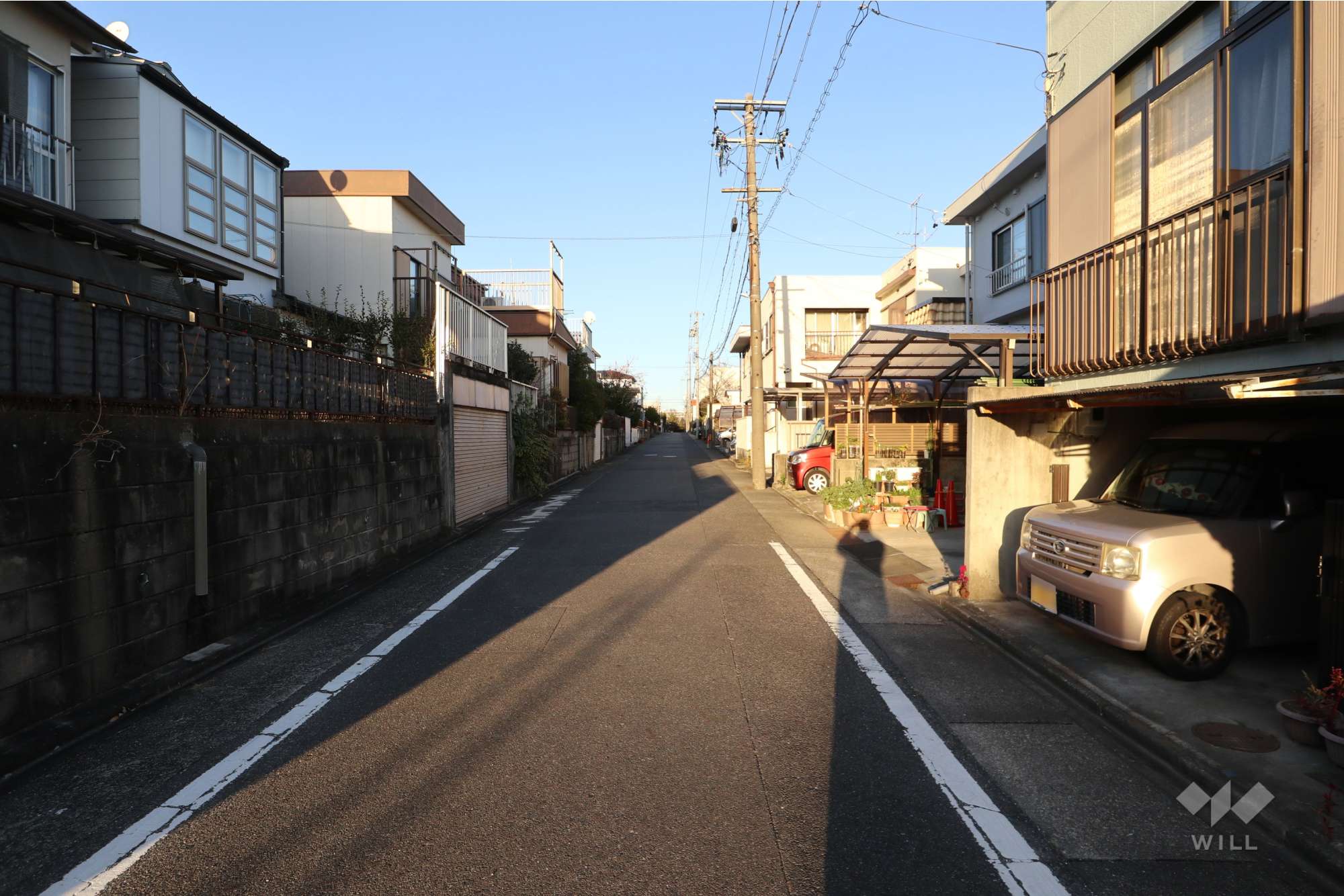 物件の南東側前面道路（南西側から）［2025年12月16日撮影］