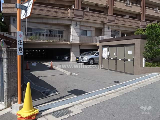 駐車場出入り口です。間口が広く、対向車がある際にも安心です。空き状況はお気軽にお問い合わせくださいませ。